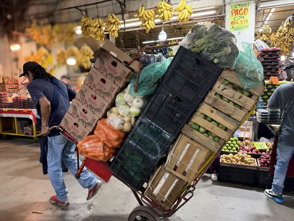 A diablero navigating the aisles of CEDA with a loaded handcart